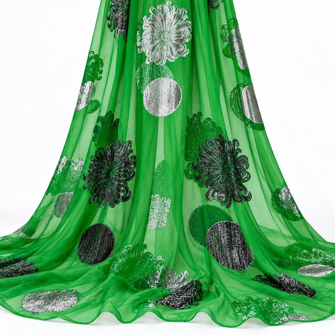 Smaragdgrønn lurex chiffonsilk med sølvfargede blomster og sirkelmotiver – hengende i myke folder på hvit bakgrunn (bilde 2 av 3)