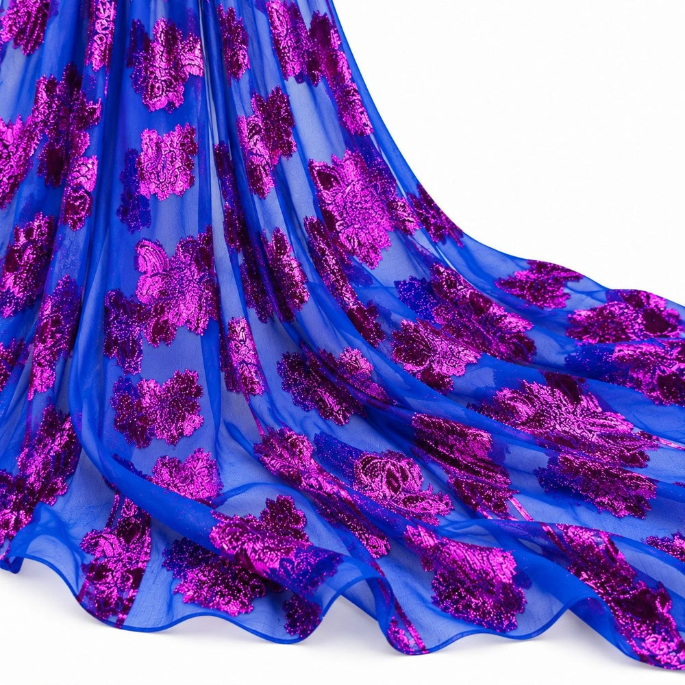 Kongeblå lurexchiffon med pink og lilla blomstermotiv – hengende i myke folder på hvit bakgrunn (bilde 2 av 3)