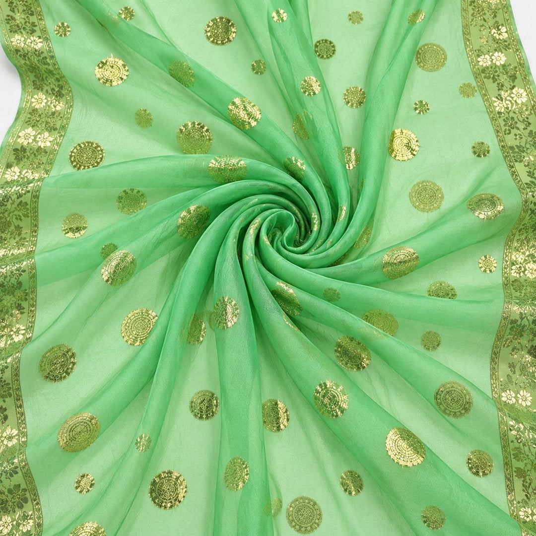 Mintgrønn lurex chiffonsilk med gylne prikkmotiver og guldborter – stoffet formet som en spiral (bilde 1 av 3)