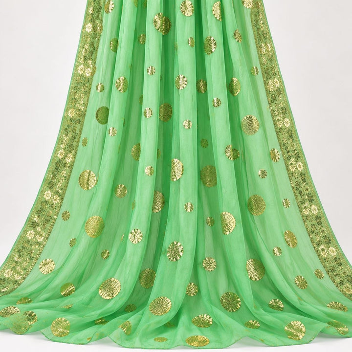 Mintgrønn lurex chiffonsilk med gylne prikkmotiver og guldborter – hengende i myke folder, guldbortene langs begge sidene synlige (bilde 2 av 3)