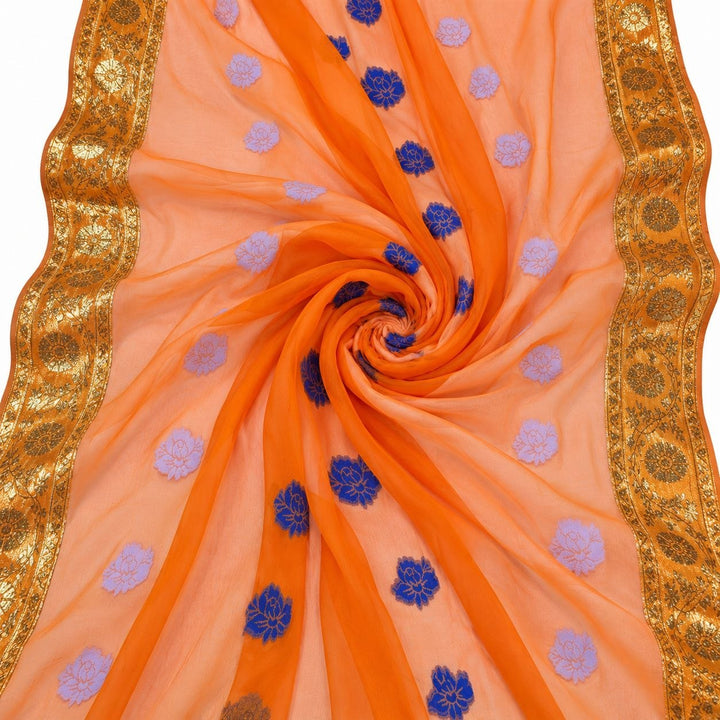 Orange lurex chiffonsilk med blå og lyslilla blomstermotiver og guldborter – stoffet formet som en spiral (bilde 1 av 3)