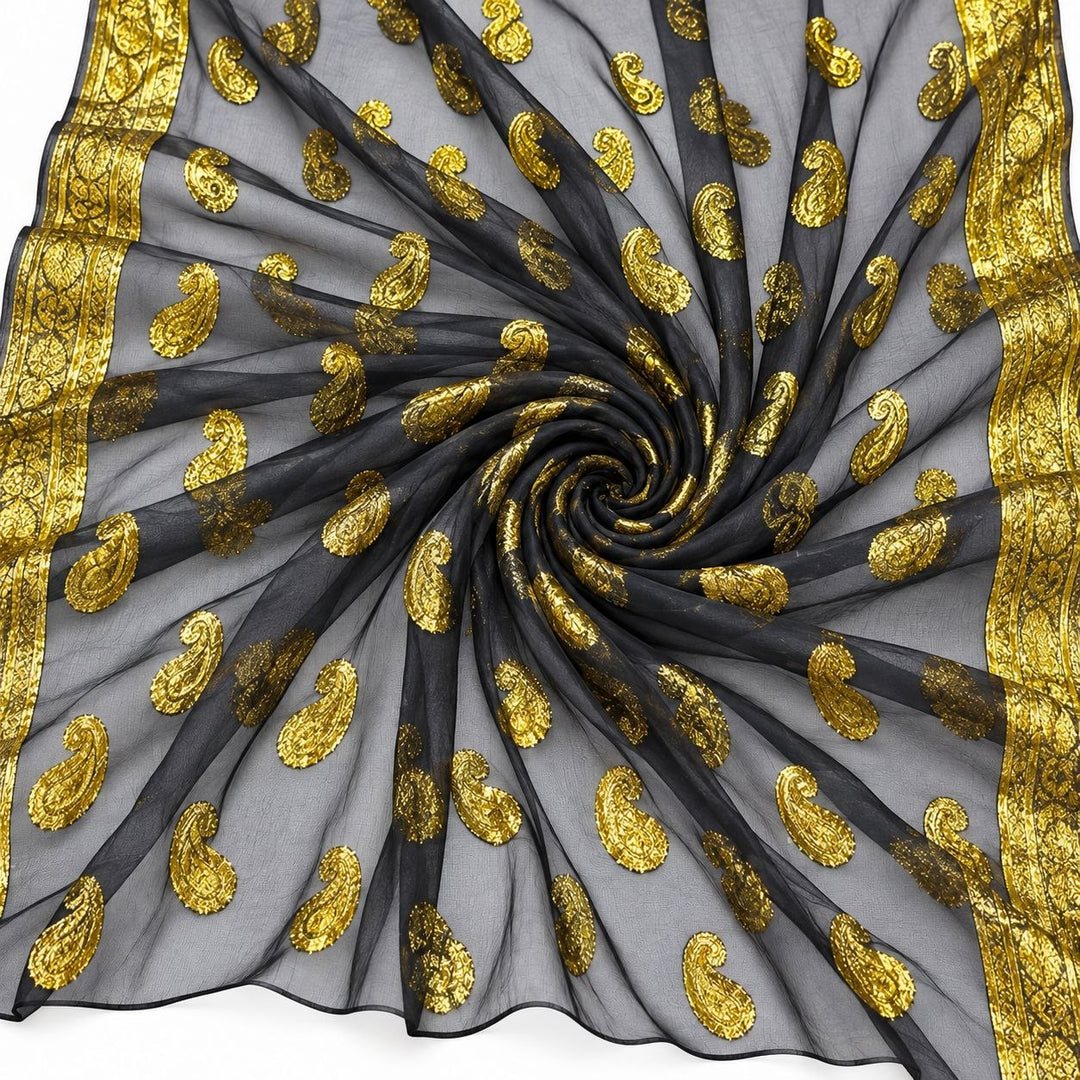 Sort lurexchiffon med gyldent paislemønster og guldborter – stoffet formet som en spiral (bilde 1 av 3)