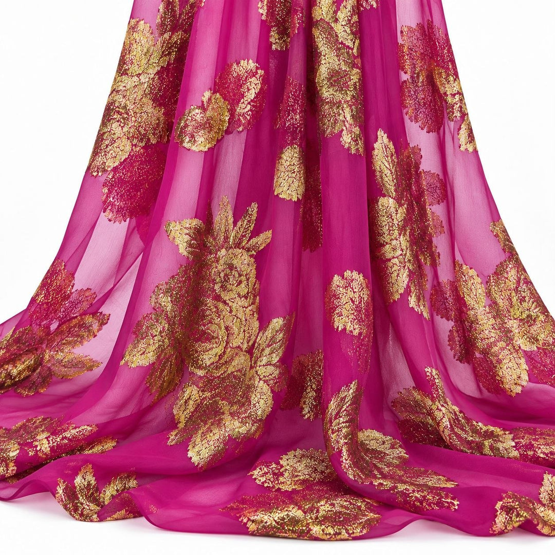 Magenta lurex chiffonsilk med store gylne blomstermotiv – hengende i myke folder på hvit bakgrunn (bilde 2 av 3)