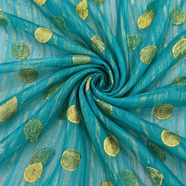 Turkis lurex chiffonsilk med gylne striper og motiver – stoffet formet som en spiral (bilde 1 av 3)