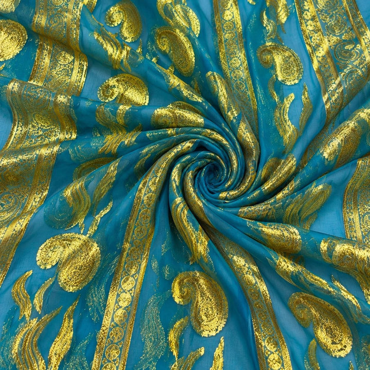 Turkis lurexchiffon med gylne paisleymønster og guldborter – stoffet formet som en spiral (bilde 1 av 3)
