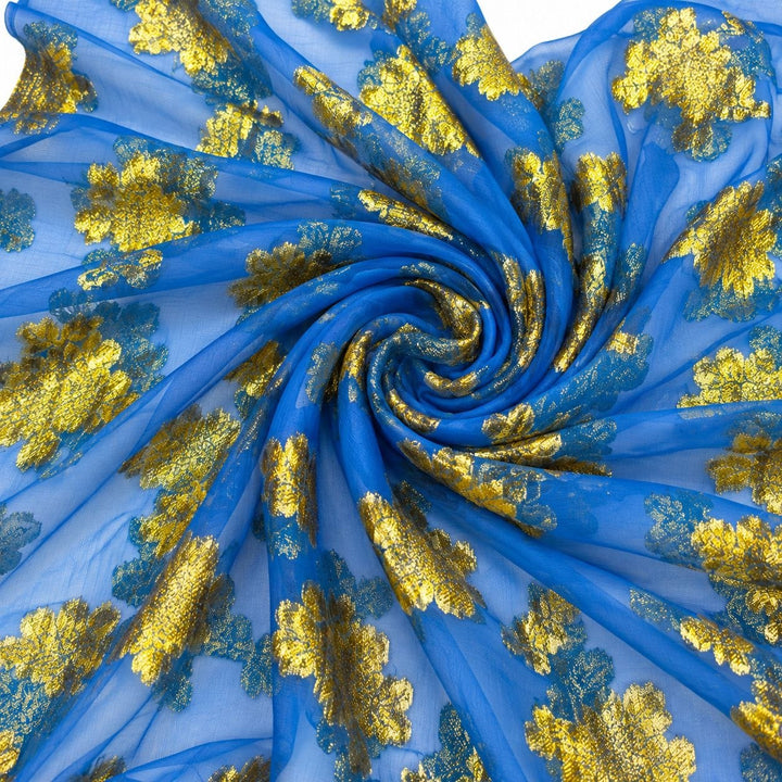 Kongeblå lurexchiffon med gyldent blomstermønster – stoffet formet som en spiral (bilde 1 av 3)