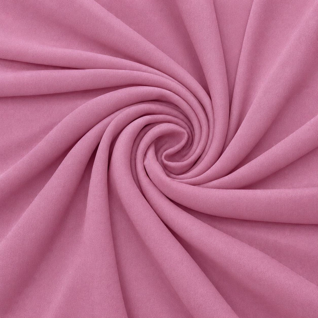 Støvet rosa silkegeorgette – stoffet formet som en spiral, der den creppede overflaten synes (bilde 1 av 3)