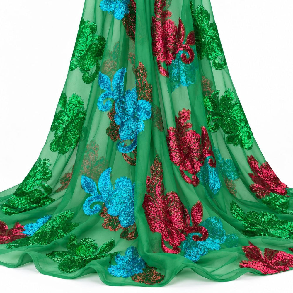 Grønn lurexchiffon med fargerike blomstermotiv – hengende i myke folder på hvit bakgrunn (bilde 2 av 3)