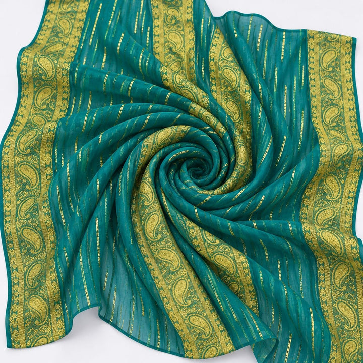 Turkis lurex chiffonsilk med gylne striper og fire brede guldborter – stoffet formet som en spiral (bilde 1 av 3)