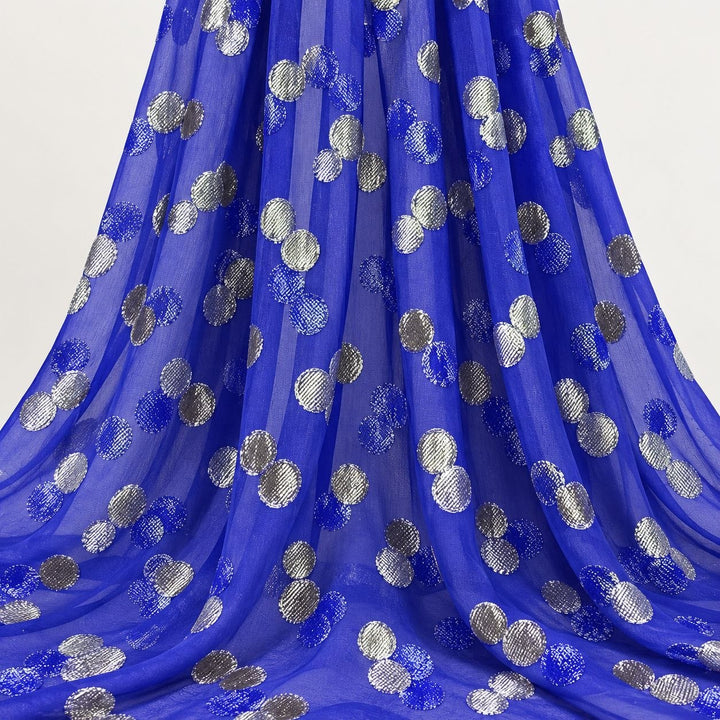 Kongeblå lurex chiffonsilk med sølv og blå prikker – hengende i myke folder på hvit bakgrunn (bilde 2 av 3)
